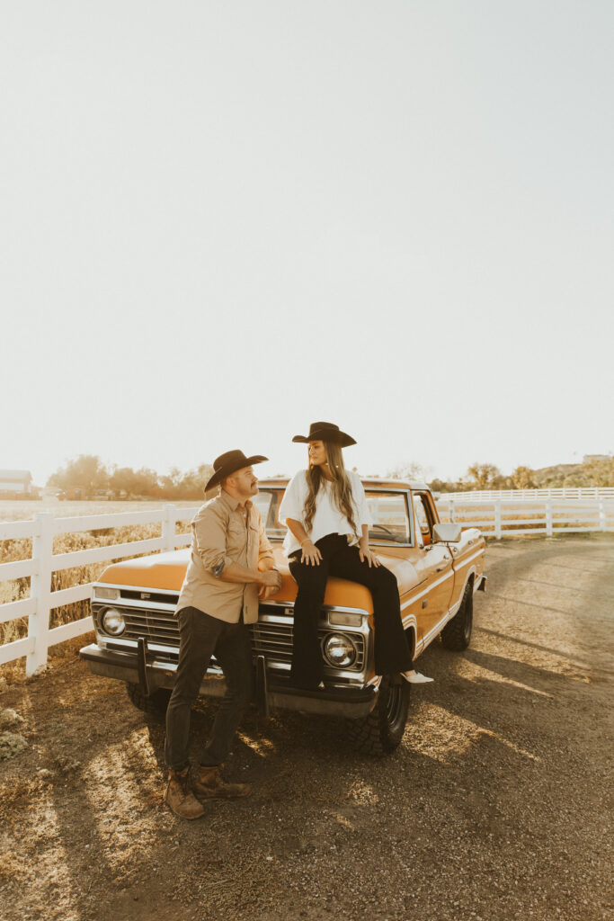 couple posing in front of their old ford truck for their western engagement photography session
