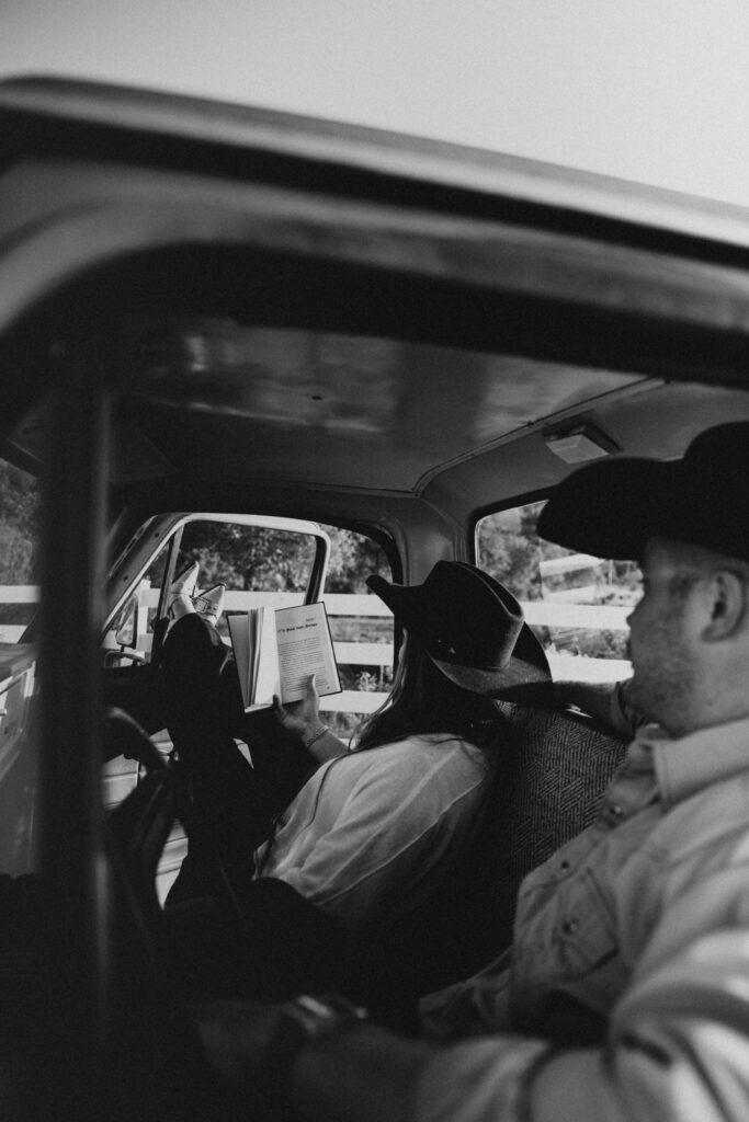 black and white image of couple sitting inside of their old ford truck for their western engagement photography session