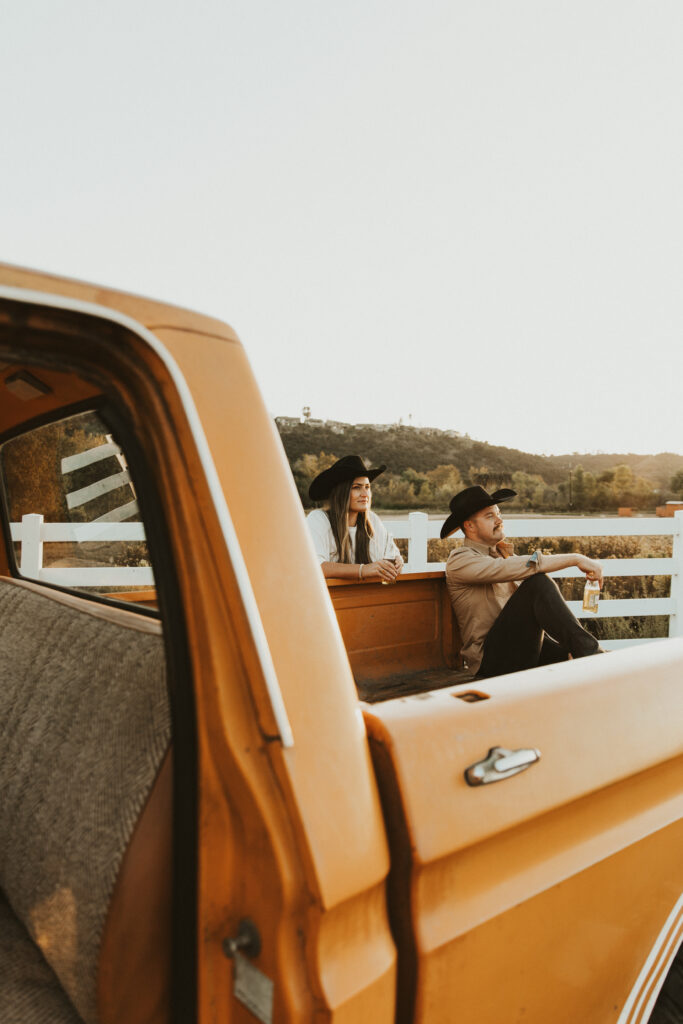 couple sitting in bed of ford truck for their engagement photos